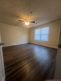 unfurnished room with baseboards, a ceiling fan, and dark wood-style floors