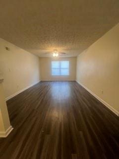 spare room featuring baseboards and dark wood-style floors