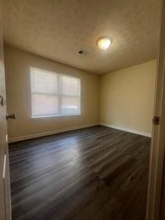 spare room with dark wood-style flooring and baseboards