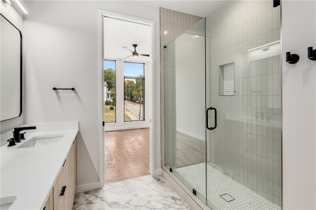 bathroom featuring a shower with door, vanity, and ceiling fan