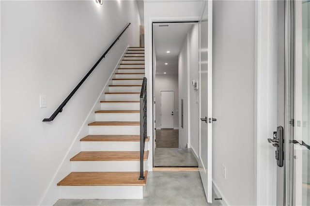 stairs with concrete flooring