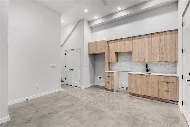 kitchen with sink, decorative backsplash, and light brown cabinets