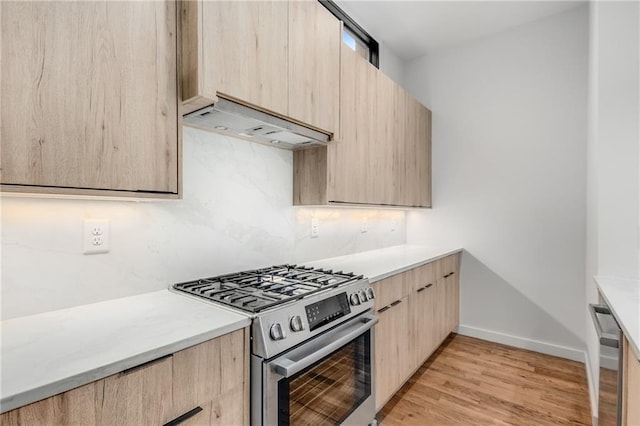 kitchen featuring light brown cabinets, light hardwood / wood-style flooring, decorative backsplash, extractor fan, and appliances with stainless steel finishes