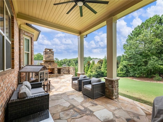 view of patio / terrace with ceiling fan and an outdoor living space with a fireplace