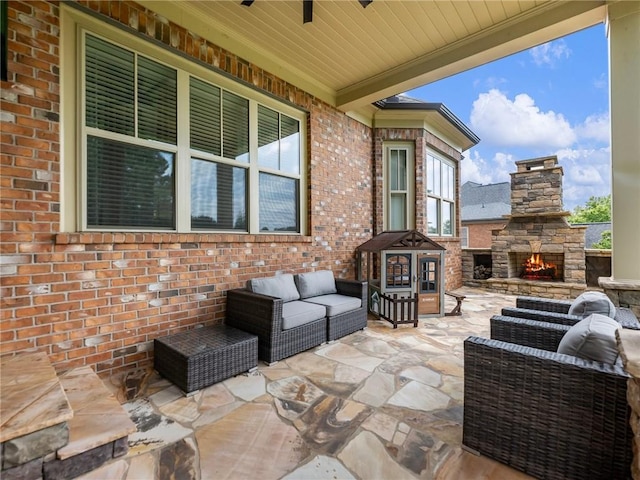 view of patio with ceiling fan and an outdoor living space with a fireplace