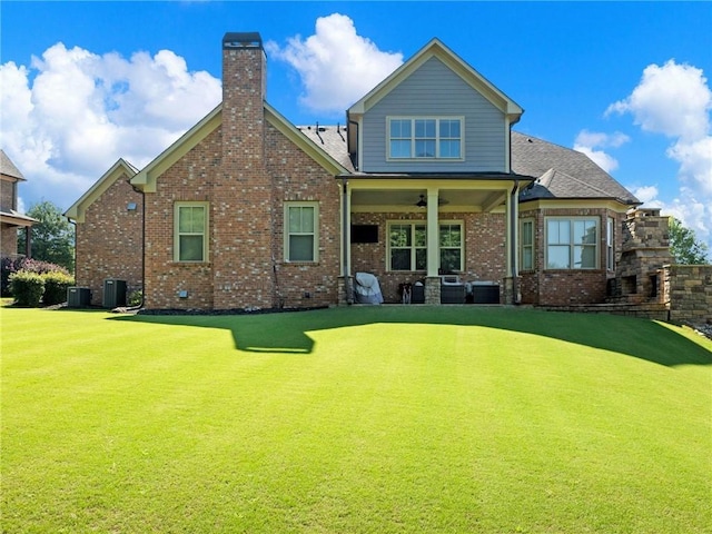 back of property with ceiling fan, central AC unit, and a lawn