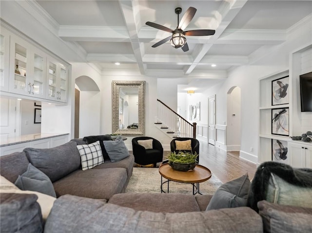 living room featuring coffered ceiling, hardwood / wood-style floors, crown molding, and beamed ceiling