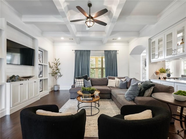 living room featuring ceiling fan, dark hardwood / wood-style floors, coffered ceiling, crown molding, and beam ceiling