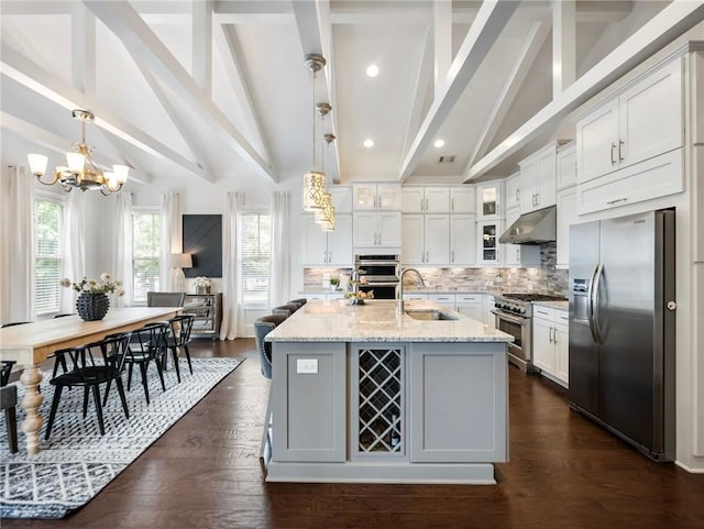 kitchen featuring hanging light fixtures, stainless steel appliances, tasteful backsplash, white cabinetry, and sink