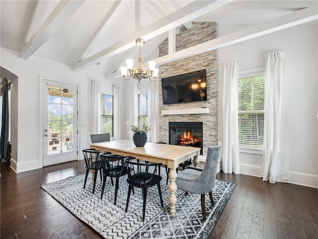 dining area featuring a chandelier, lofted ceiling with beams, plenty of natural light, and a fireplace