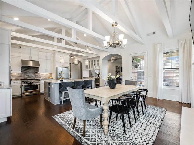 dining space with ceiling fan with notable chandelier, lofted ceiling with beams, and dark hardwood / wood-style flooring