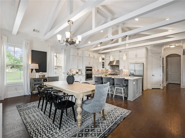 dining space featuring a chandelier, vaulted ceiling with beams, and dark hardwood / wood-style floors