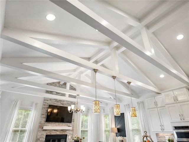 interior space featuring a fireplace, a chandelier, a healthy amount of sunlight, and vaulted ceiling with beams