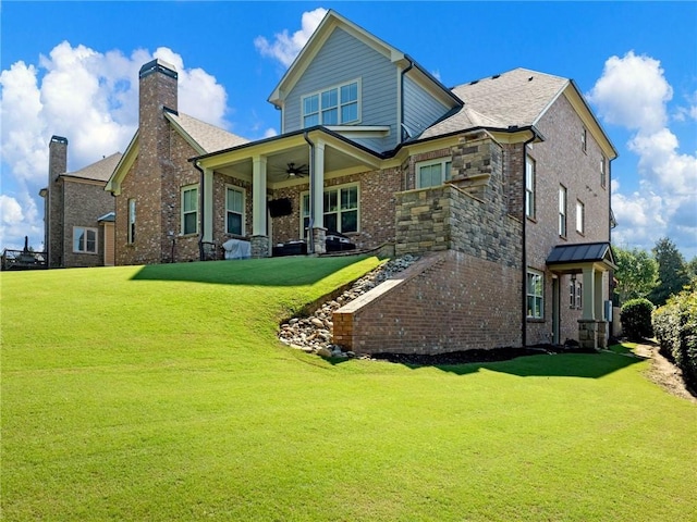 back of house featuring ceiling fan and a yard