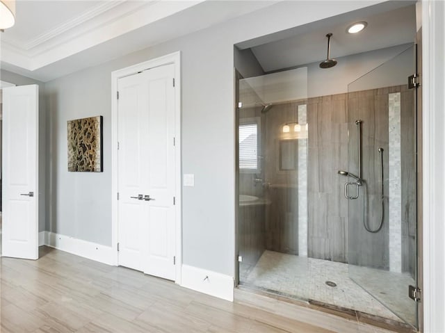 bathroom with crown molding and a shower with shower door