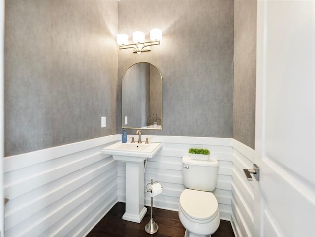 bathroom with hardwood / wood-style flooring and toilet