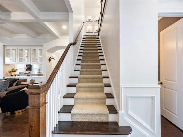 stairway with hardwood / wood-style flooring, beam ceiling, ornamental molding, and coffered ceiling