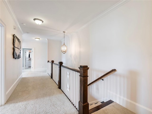 hallway with light colored carpet, crown molding, and a chandelier