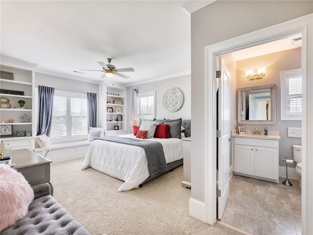 bedroom featuring ensuite bath, ceiling fan, light carpet, and ornamental molding