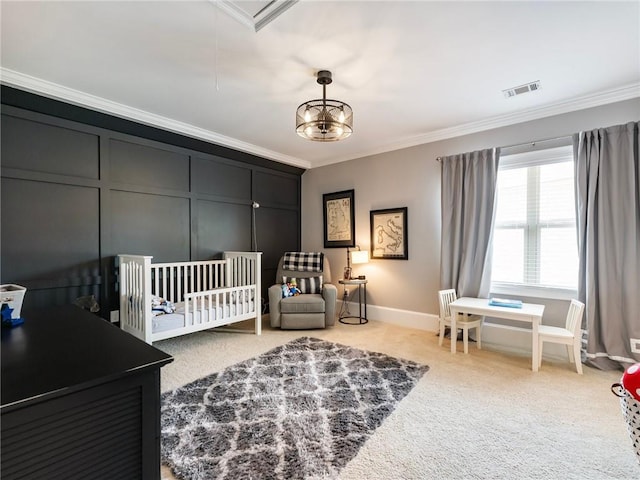 bedroom featuring a crib, an inviting chandelier, ornamental molding, and light colored carpet