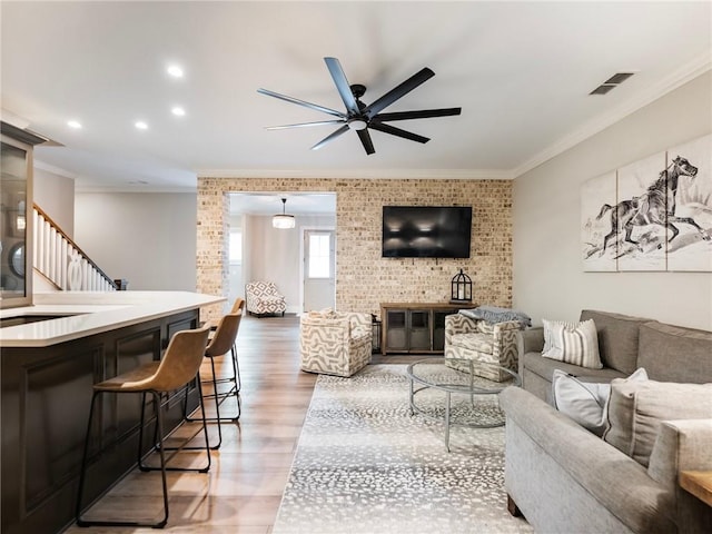 living room with ceiling fan, crown molding, and hardwood / wood-style flooring