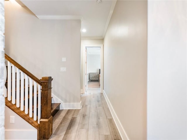 hall with light hardwood / wood-style flooring and crown molding