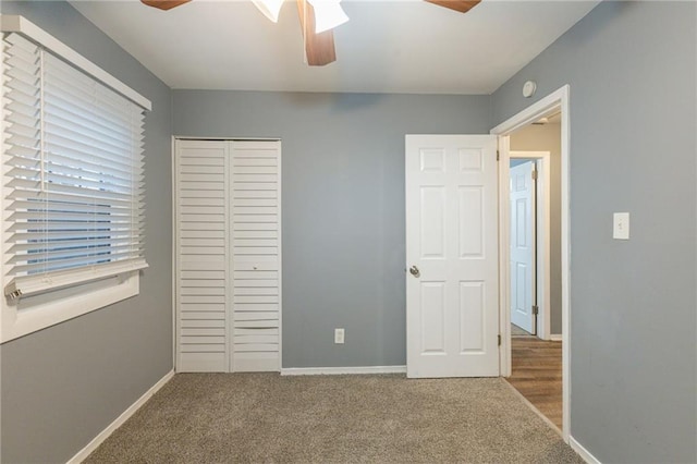 unfurnished bedroom with ceiling fan, light colored carpet, and a closet