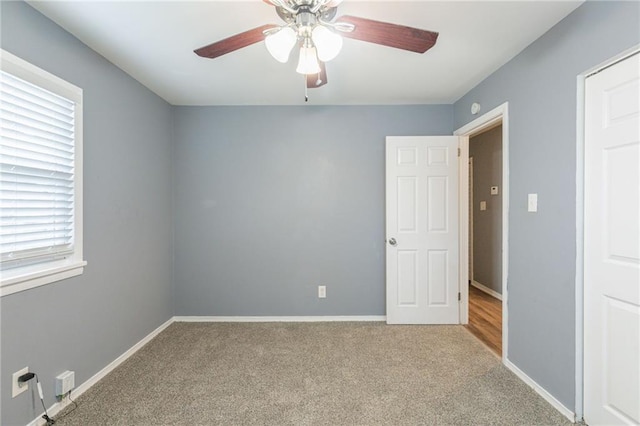 spare room with ceiling fan, a healthy amount of sunlight, and light colored carpet