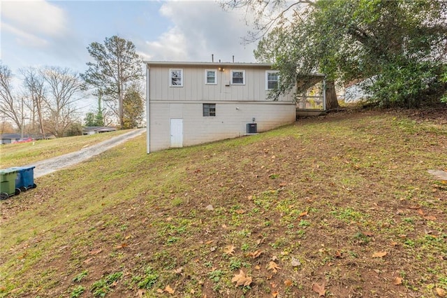 rear view of property featuring a yard and central AC unit