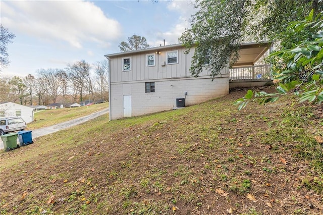 rear view of property with central air condition unit and a wooden deck