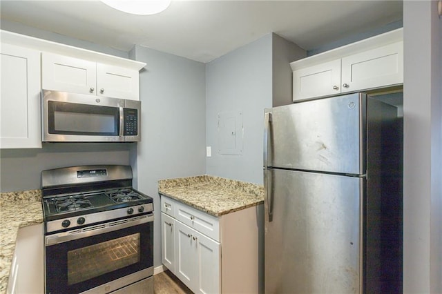 kitchen featuring white cabinets, stainless steel appliances, and light stone countertops