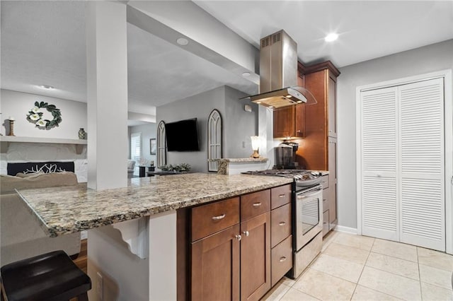 3408 Lake Pointe Cir, Roswell, GA 30075 - kitchen with island exhaust hood, stainless steel gas stove, a peninsula, light stone countertops, and light tile patterned floors