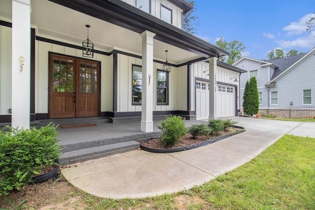 2638 Clairmont Rd, Atlanta, GA 30329 - property entrance with board and batten siding, a porch, concrete driveway, and a garage