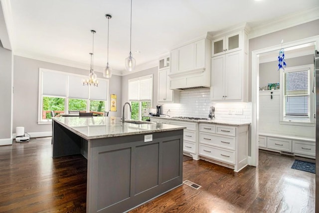 2638 Clairmont Rd, Atlanta, GA 30329 - kitchen featuring ornamental molding, healthy amount of natural light, a kitchen island with sink, tasteful backsplash, and light stone countertops