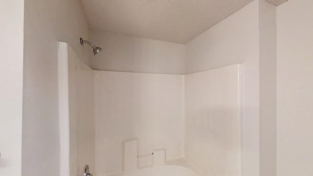 bathroom featuring a textured ceiling and shower / bathtub combination