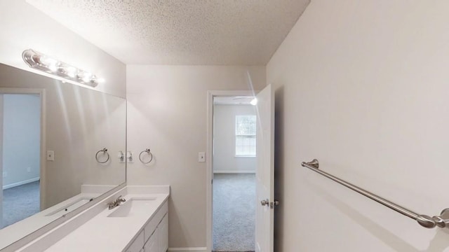 bathroom featuring a textured ceiling, vanity, and baseboards