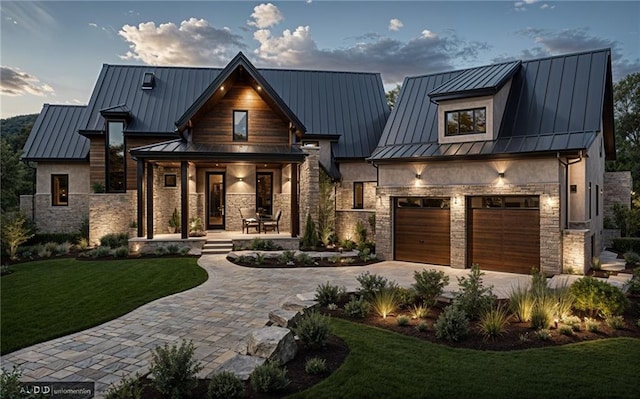 modern farmhouse style home featuring a garage, a lawn, and covered porch