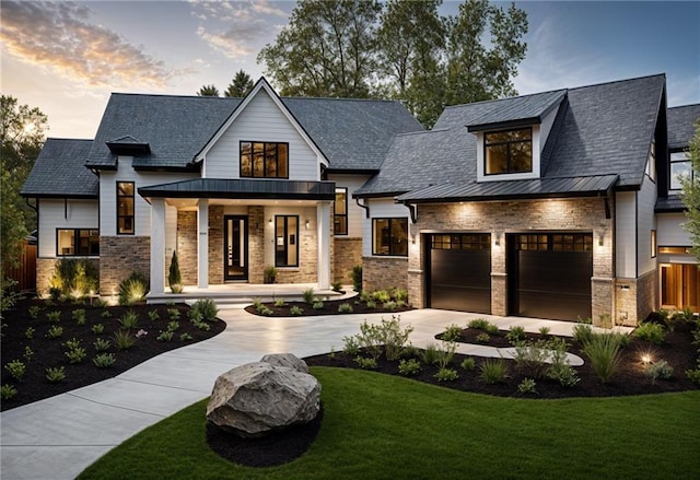 modern inspired farmhouse featuring a porch, a garage, and a lawn