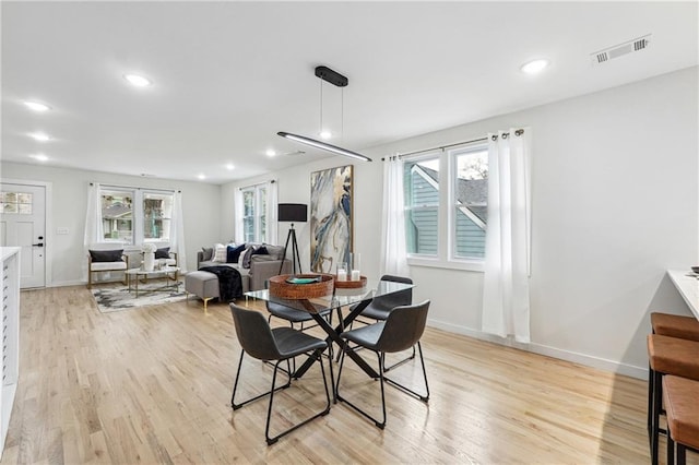 dining space with plenty of natural light and light wood-type flooring