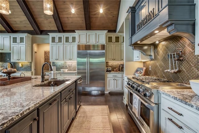 kitchen featuring high quality appliances, decorative light fixtures, tasteful backsplash, white cabinetry, and sink