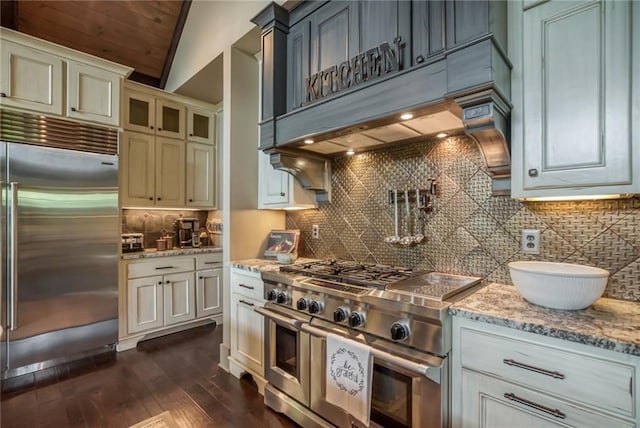 kitchen with lofted ceiling, backsplash, high end appliances, and premium range hood