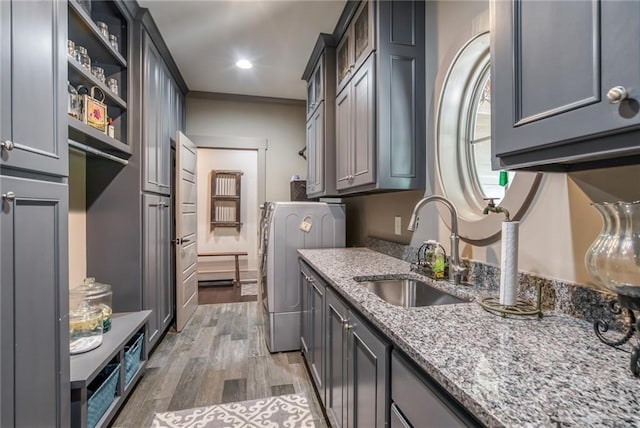 kitchen featuring light stone counters, sink, gray cabinets, light wood-type flooring, and ornamental molding