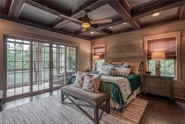 bedroom with coffered ceiling, multiple windows, dark wood-type flooring, and beam ceiling