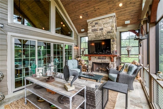 sunroom / solarium with wooden ceiling, a stone fireplace, and lofted ceiling