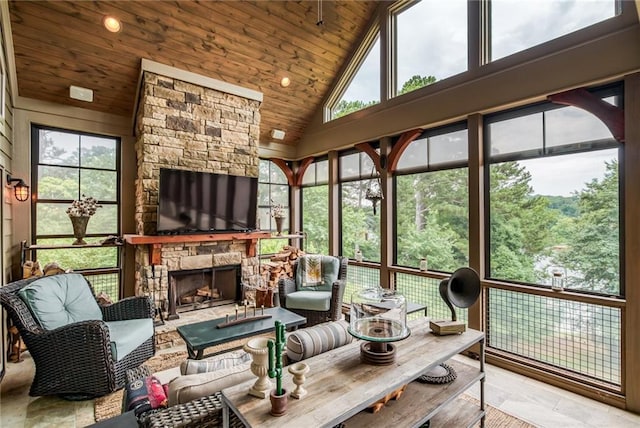 sunroom featuring wood ceiling, a fireplace, and lofted ceiling