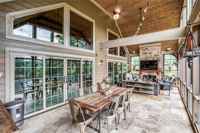 interior space with lofted ceiling, a stone fireplace, and wooden ceiling