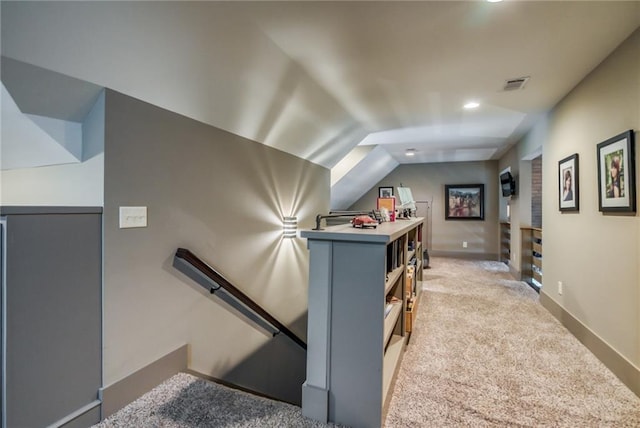 stairway with light carpet and lofted ceiling