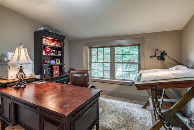 carpeted office featuring lofted ceiling