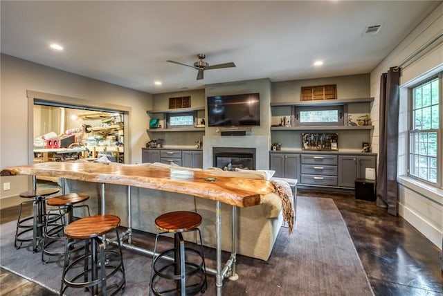 bar with ceiling fan and gray cabinets