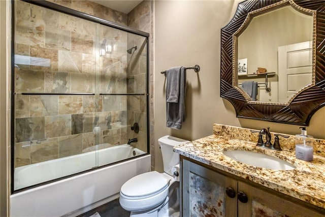 full bathroom featuring toilet, bath / shower combo with glass door, and vanity